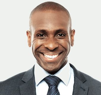 businessman-smiling-suit-portrait-grey-background-800h